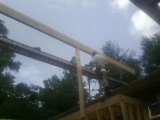 Carpenter setting a ridge beam over a new addition frame — Ice Dam Removal by Roofing Brothers in Prattsburgh