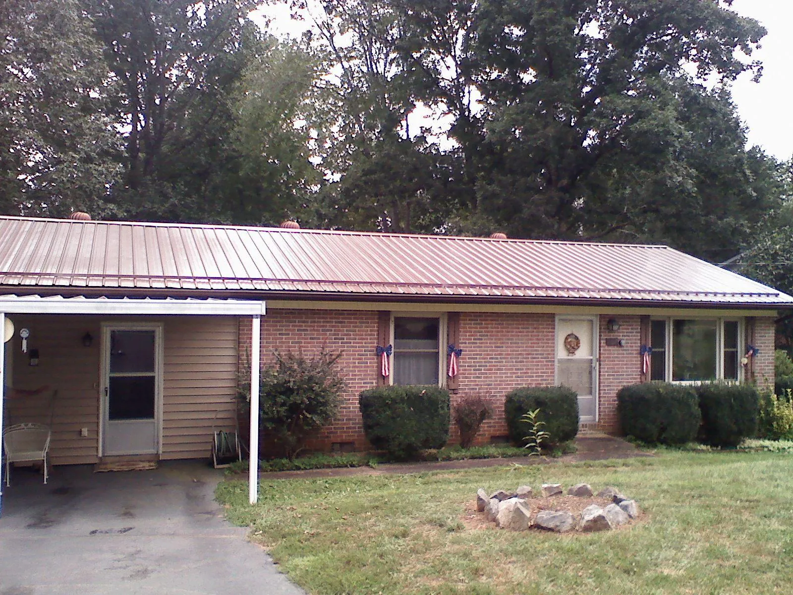 Bronze metal roof and carport on a brick ranch home — Roof Repair work by our crew in Prattsburgh